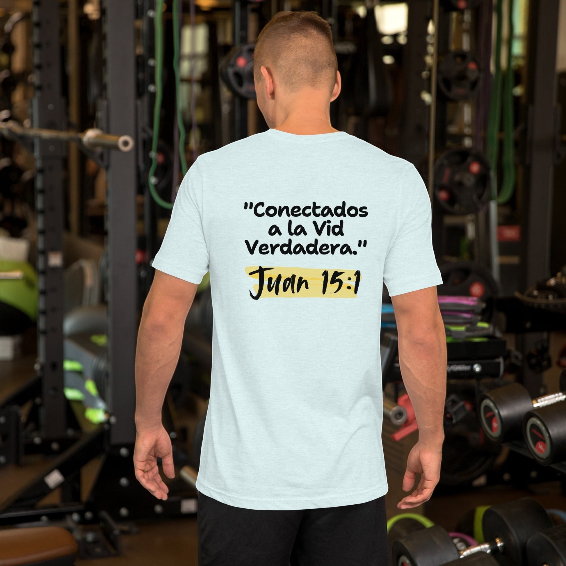 Crown & Cross Co light blue 100% cotton t-shirt with Spanish text "Conectados a la Vid Verdadera. Juan 15:1" on back. Model in gym.
